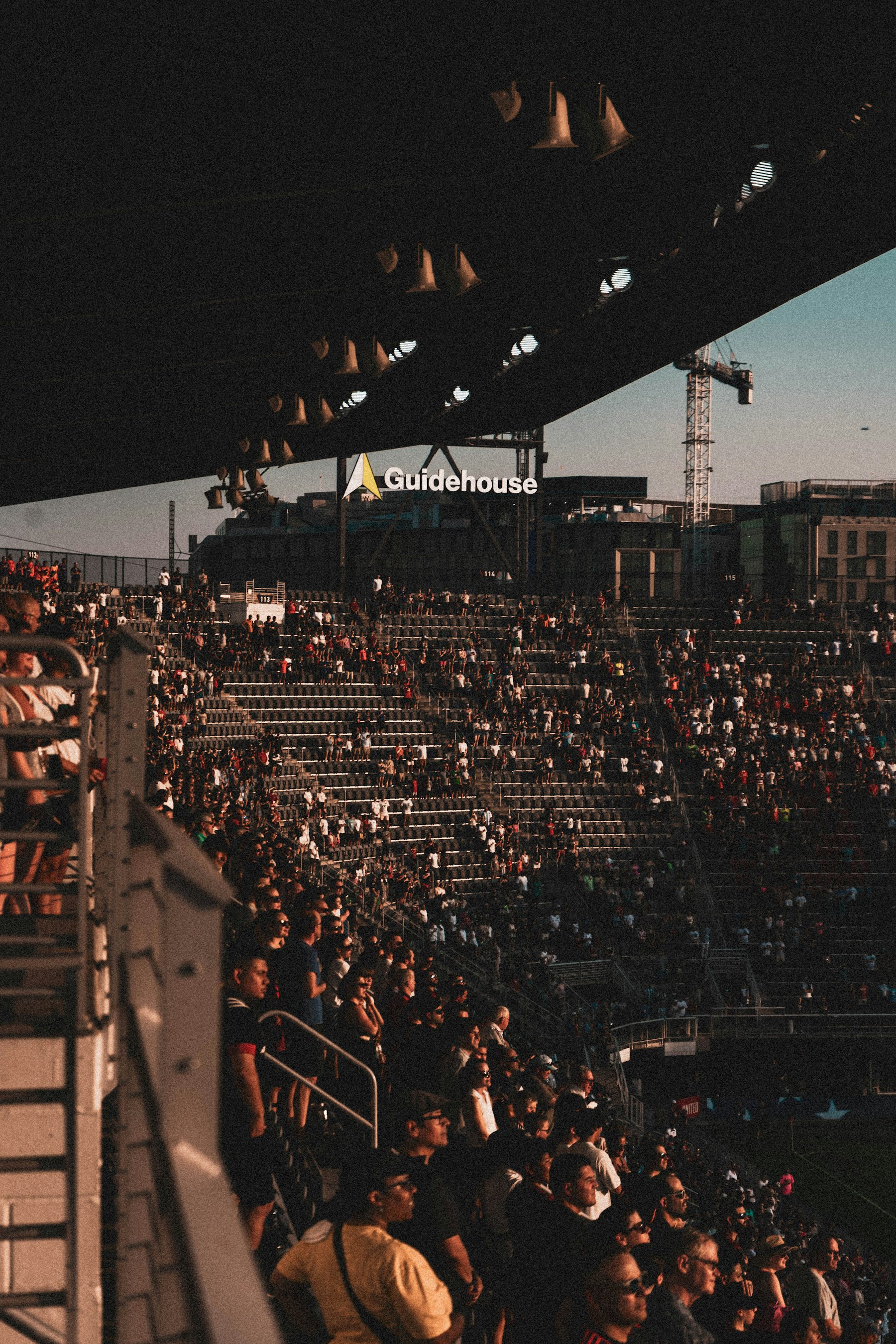Soccer player controlling the ball while the crowd watches under bright lights